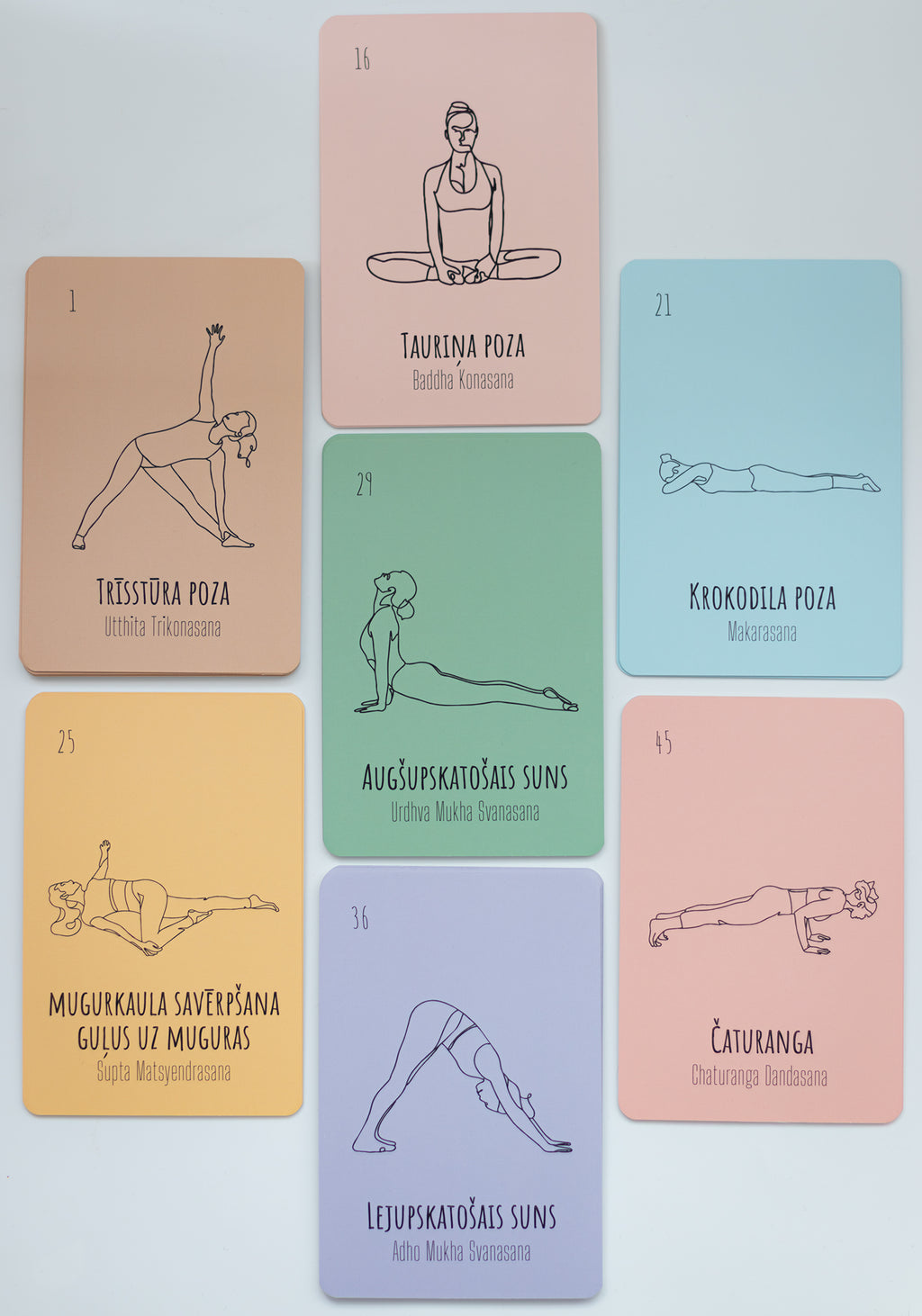 A set of yoga pose cards arranged on a light gray background. The cards are peach, pink, green, yellow, and lavender, each featuring a black line drawing of a yoga pose and Latvian text.